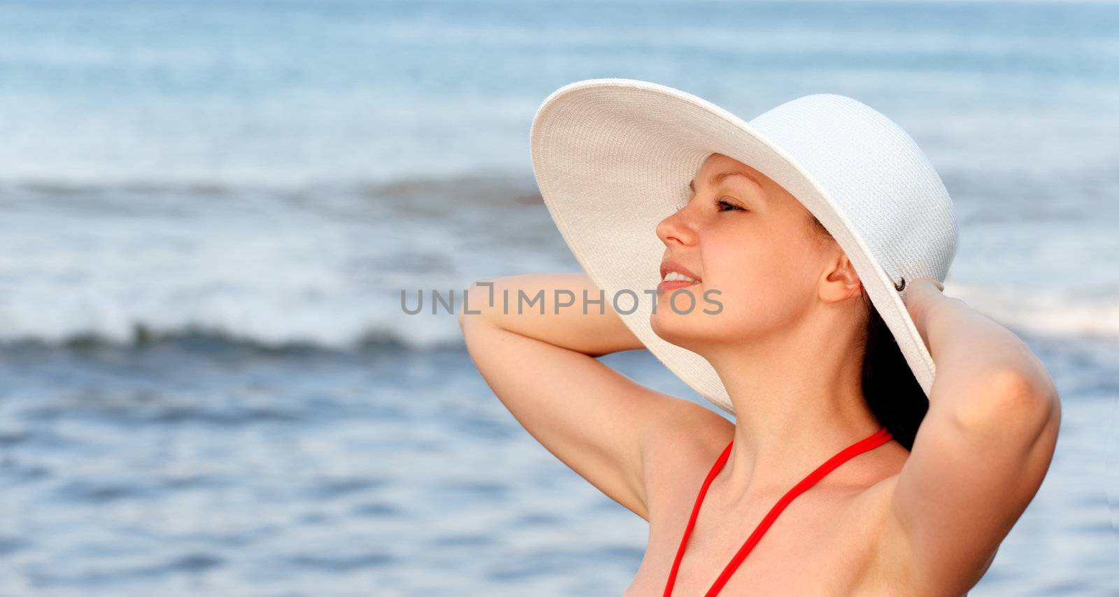 The girl in a hat against the sea 