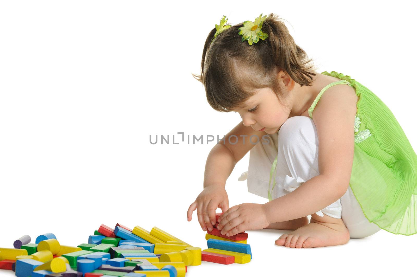 The lovely little girl plays colour wooden cubes by galdzer
