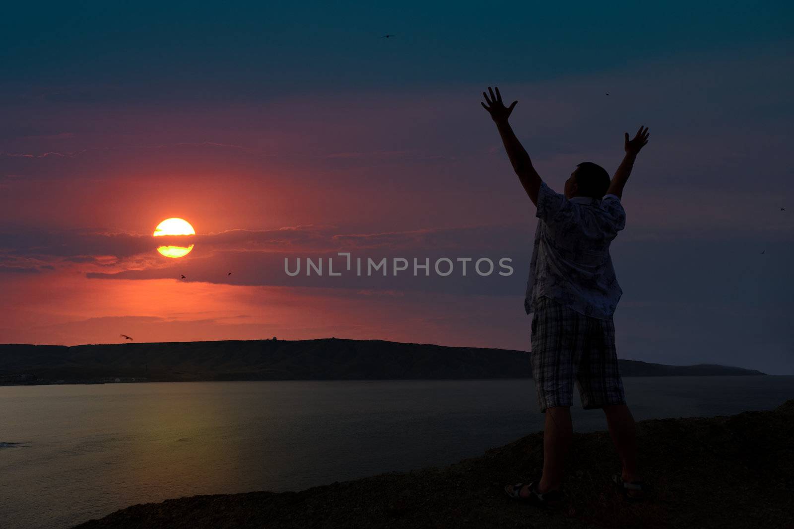 The man welcomes the sunset sun. Upwards the lifted hands