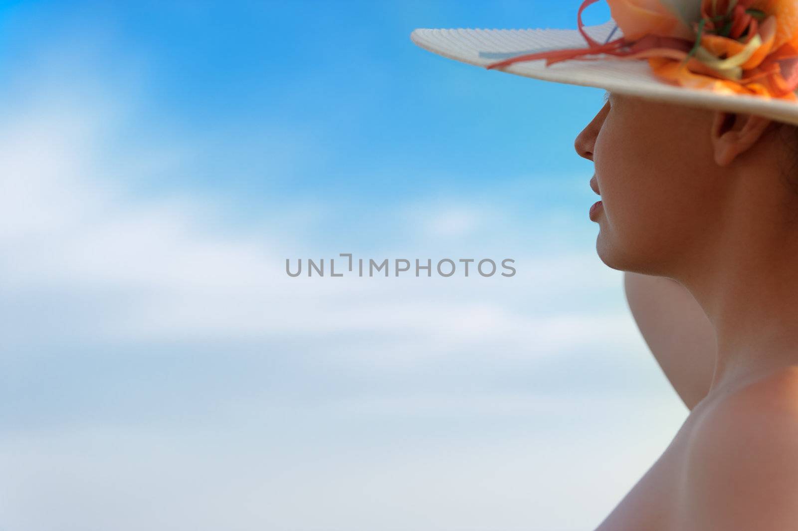 The girl in a hat against the blue sky