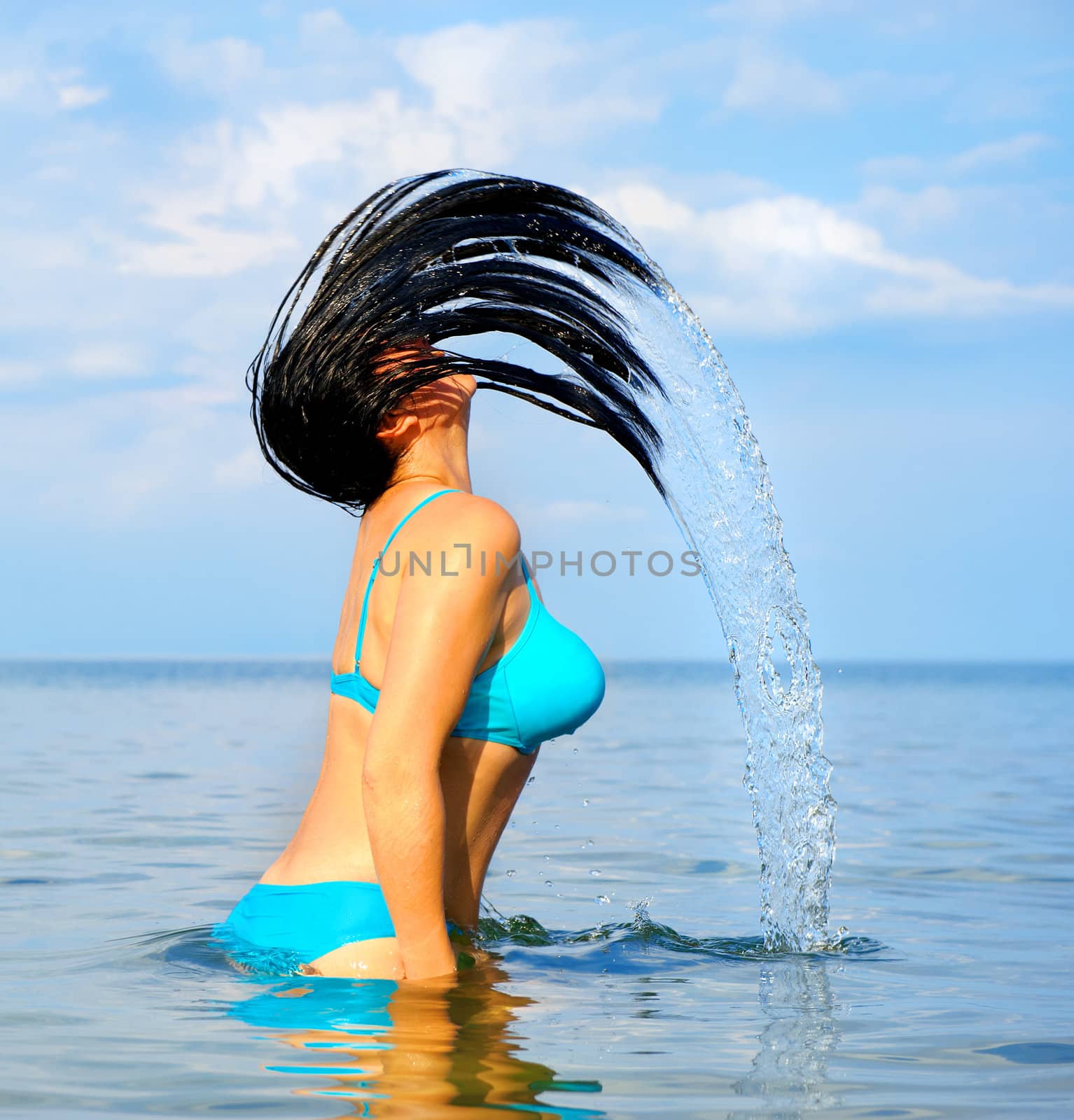 The woman with splashes from hair. Effect of movement