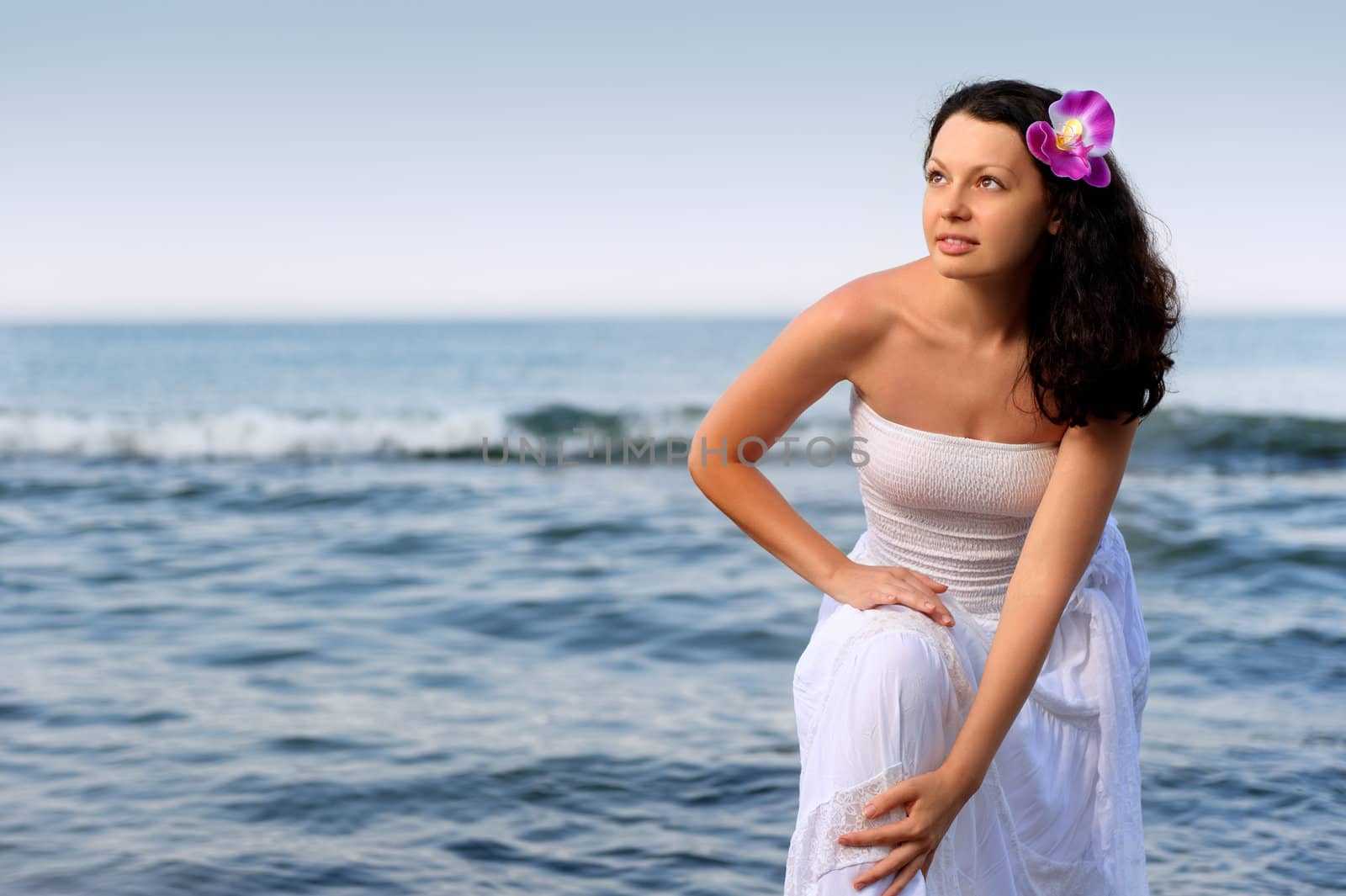 The woman in a white sundress on seacoast. A picturesque landscape