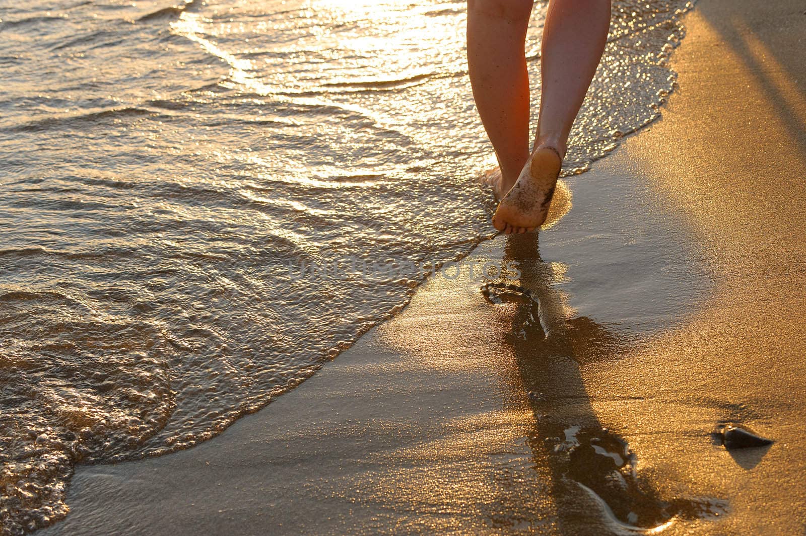 footprint on sand. Sunset illumination, a fragment of female feet