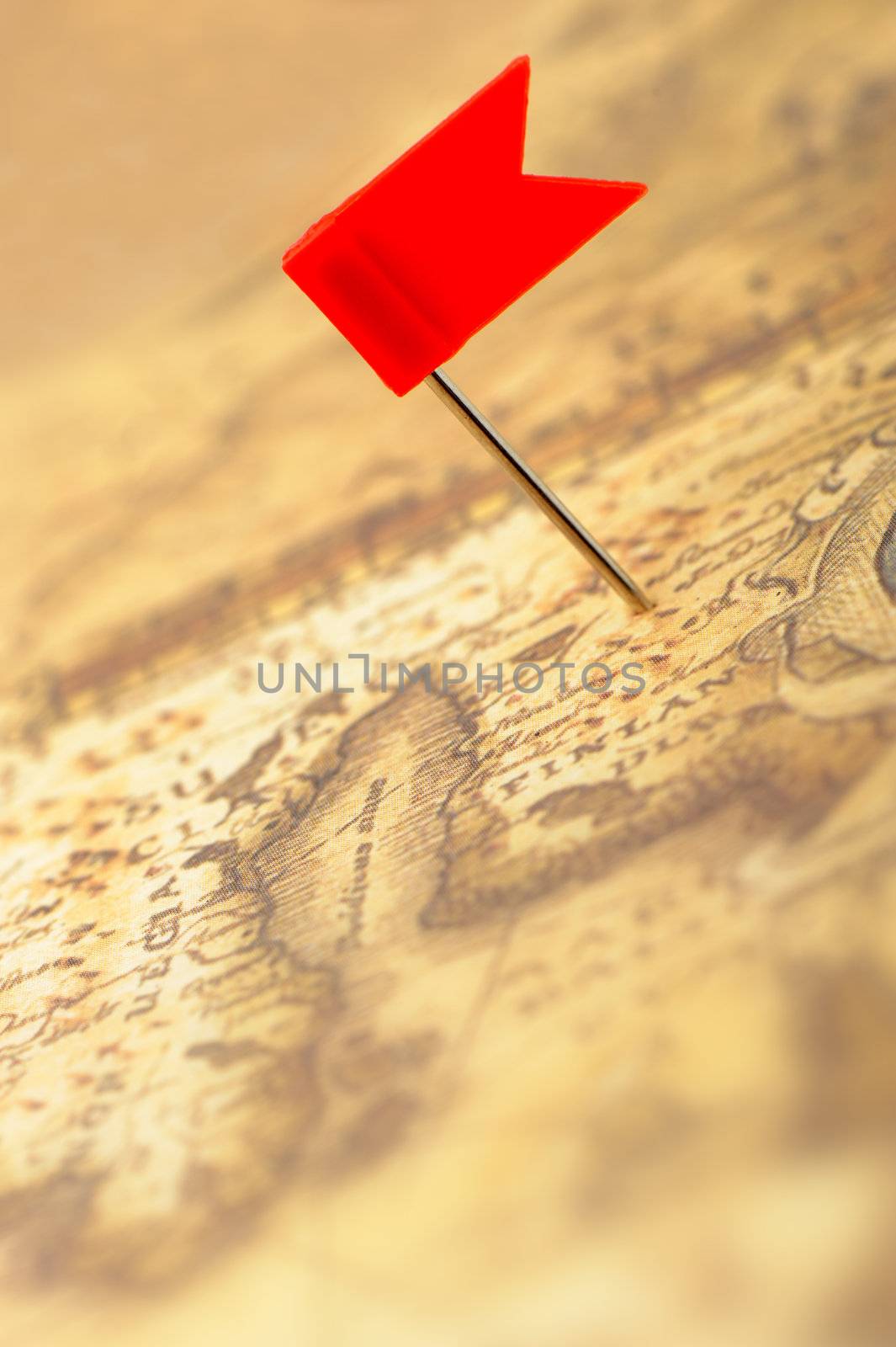 Flag red a pin on old map. Photo closeup. Selective focus