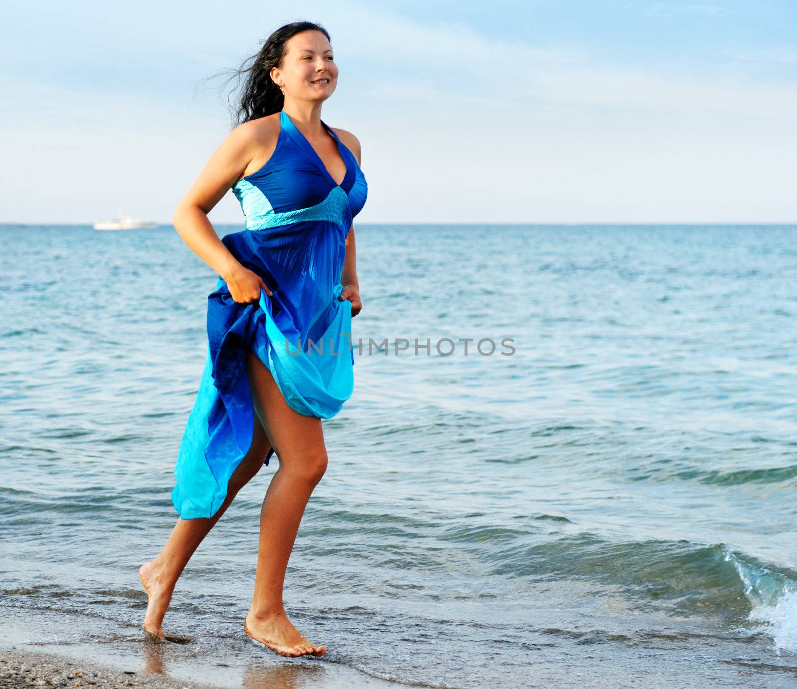 The woman runs on sea coast. A picturesque landscape