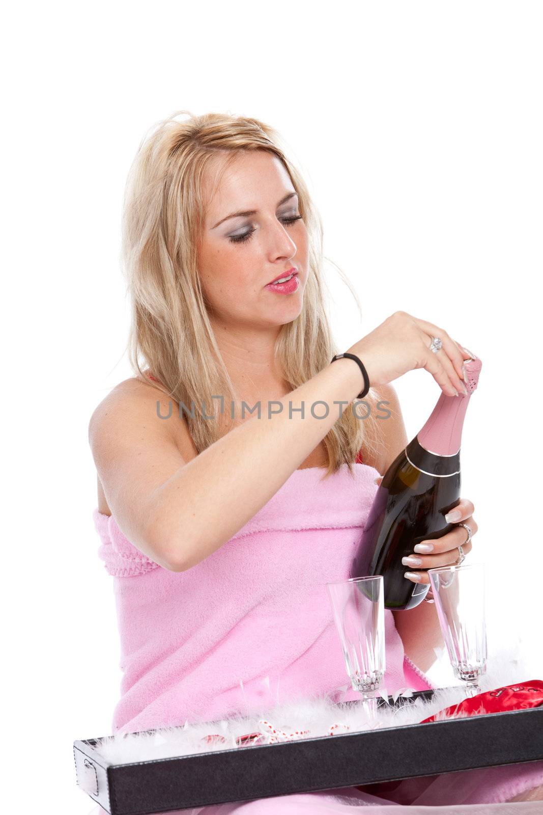 Pretty blond woman opening a champagne bottle