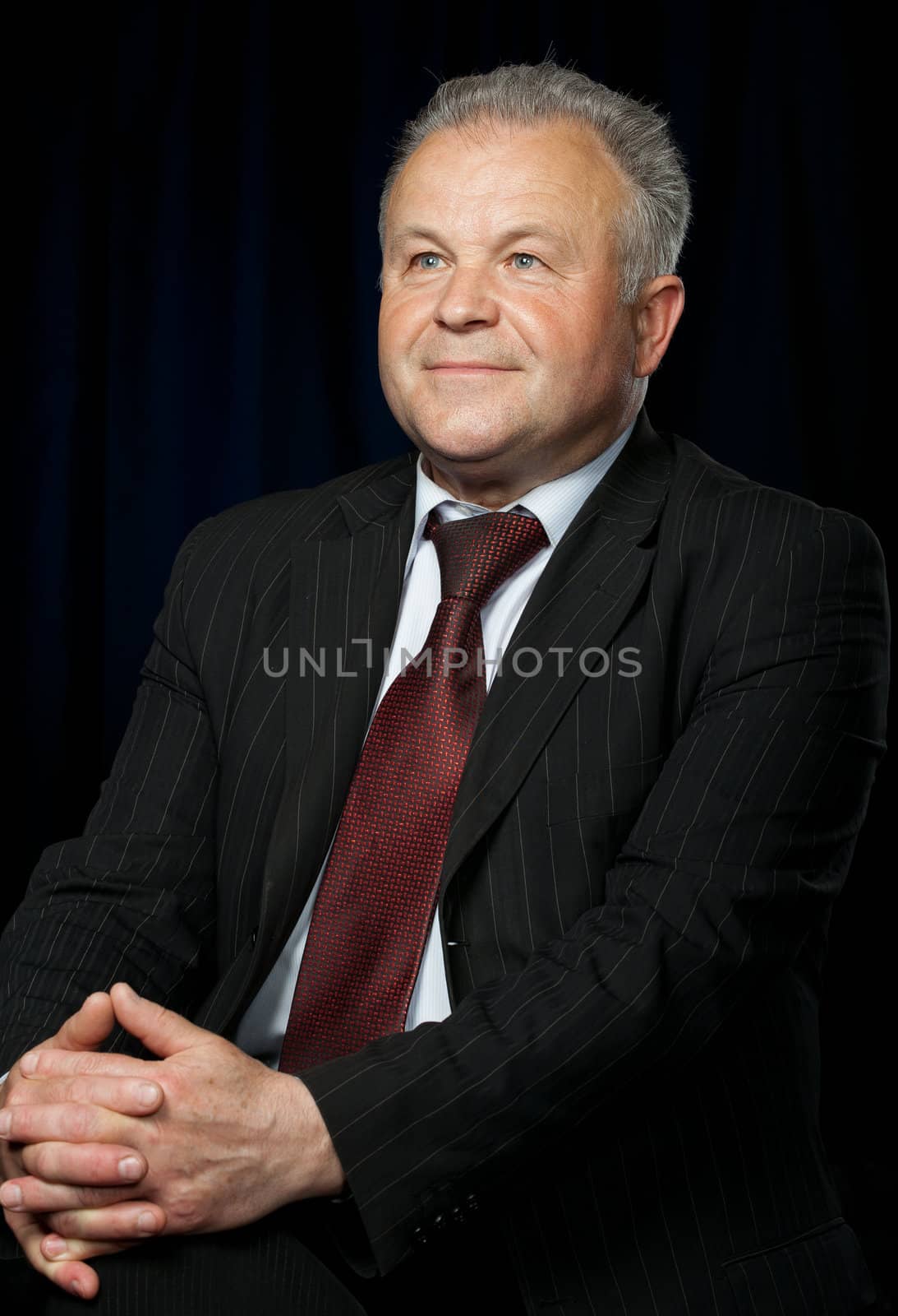 Portrait of the elderly man. A photo against a dark background