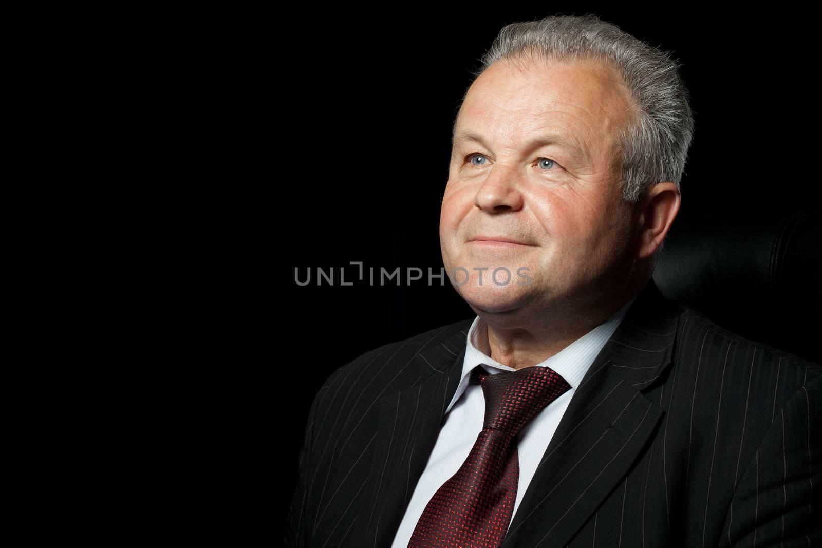 Portrait of the elderly man. A photo against a dark background