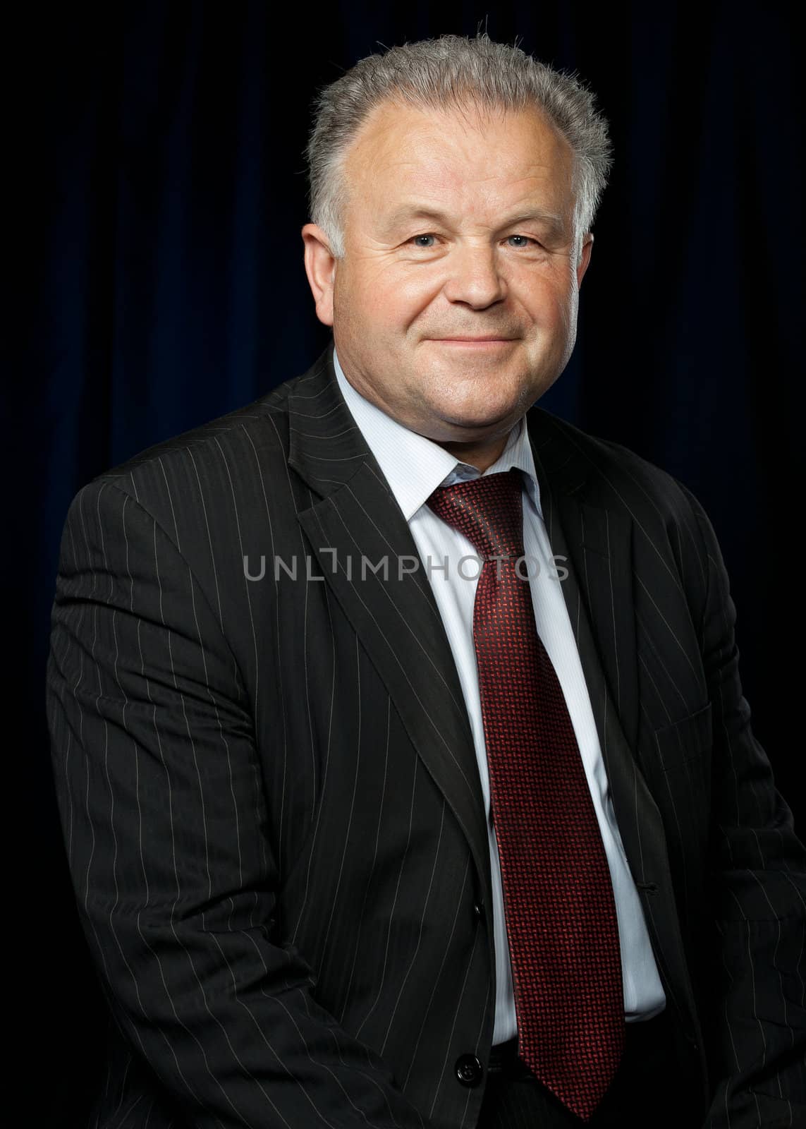 Portrait of the elderly man. A photo against a dark background