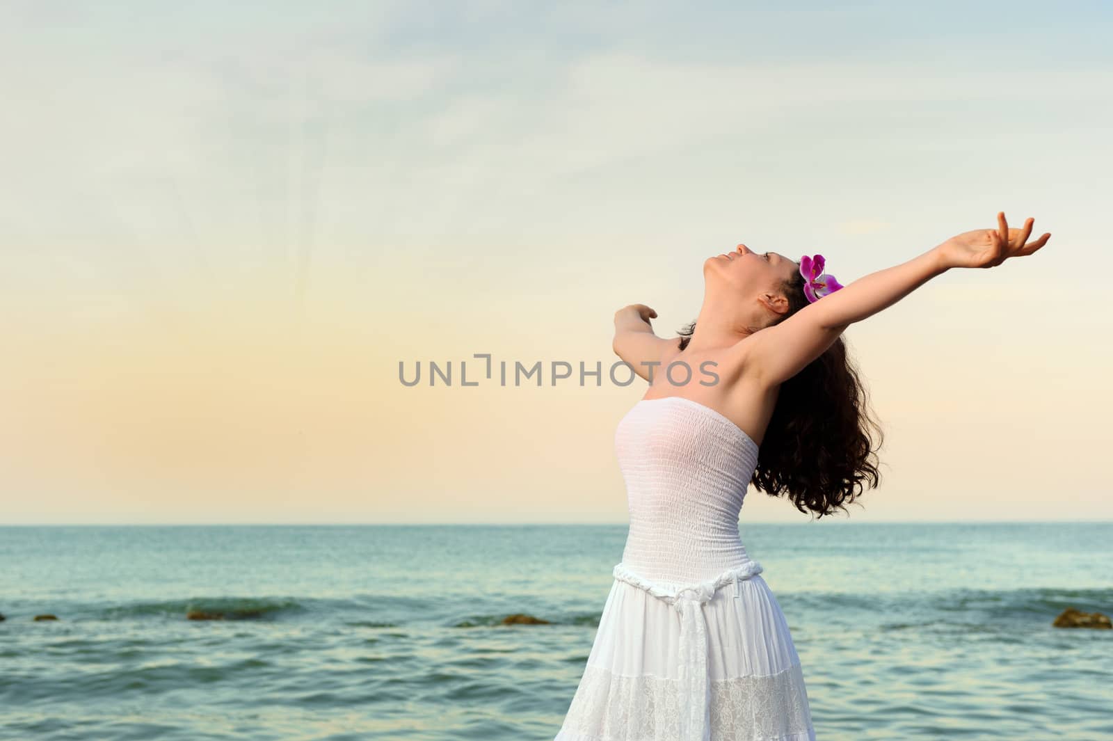 The woman in a white sundress on seacoast open hands by galdzer