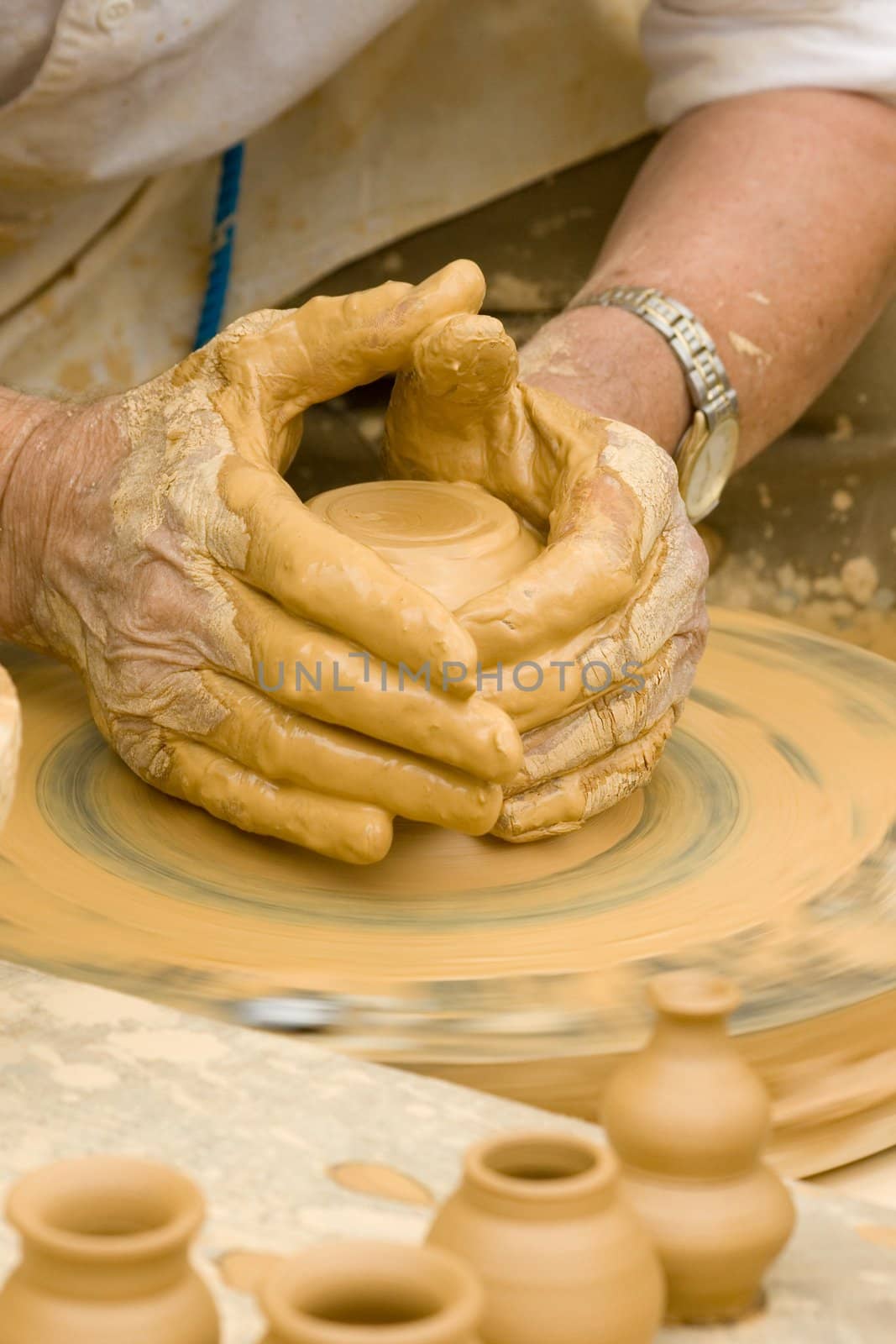 Close-up of hands making pottery on a wheel