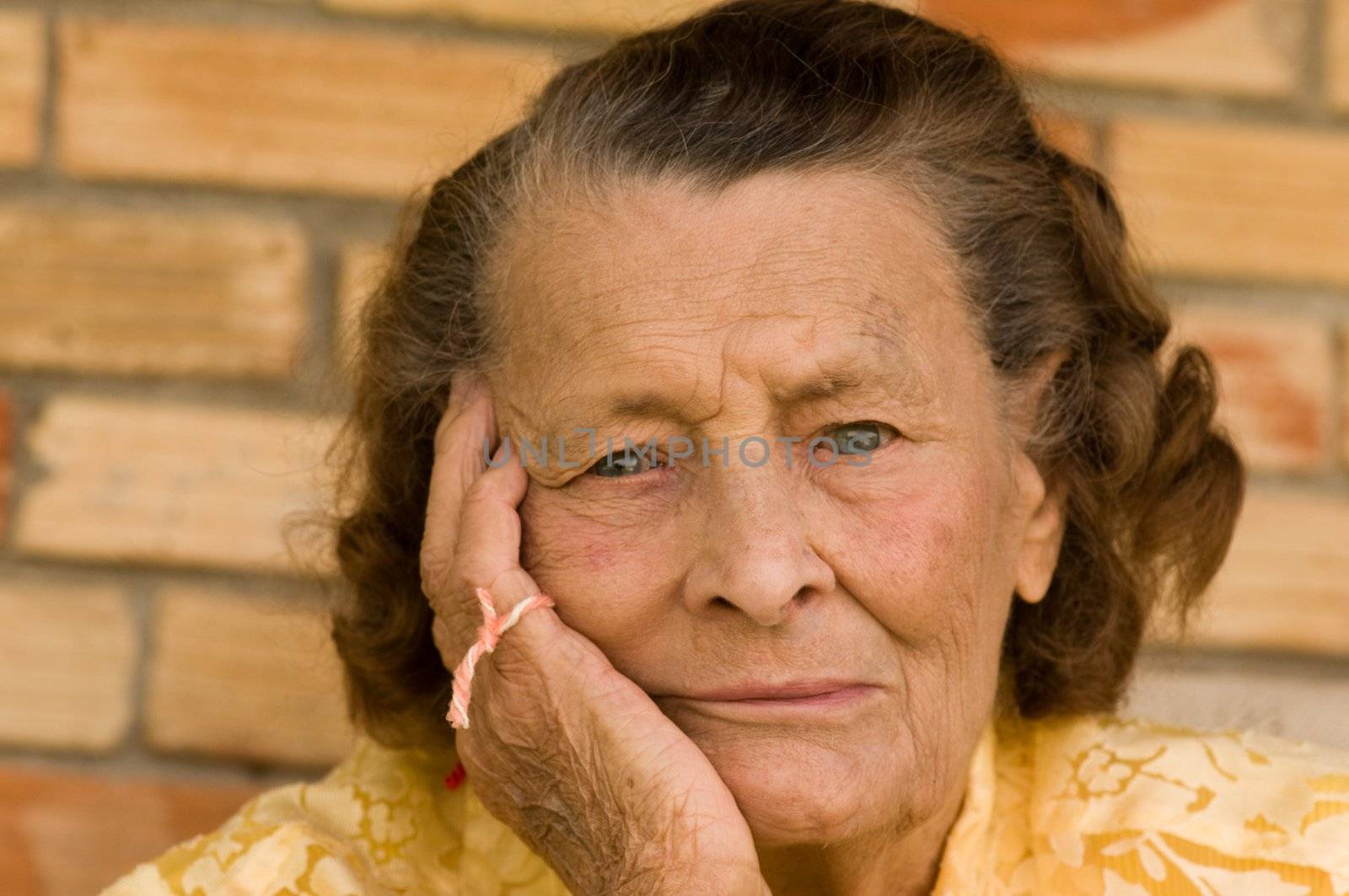 horizontal of senior caucasian woman with head in hand and string on fingers wondering what she forget