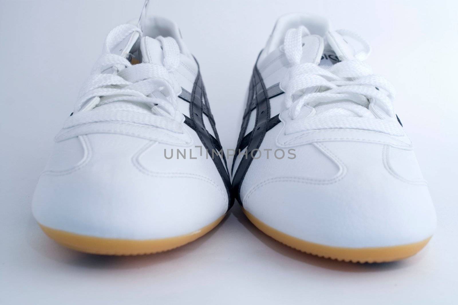 White gym shoes on white background by olgaolga
