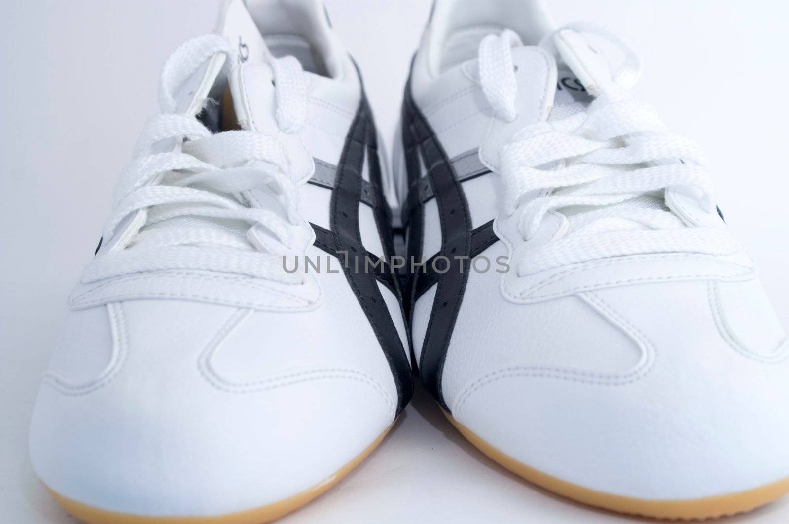 White gym shoes on white background by olgaolga