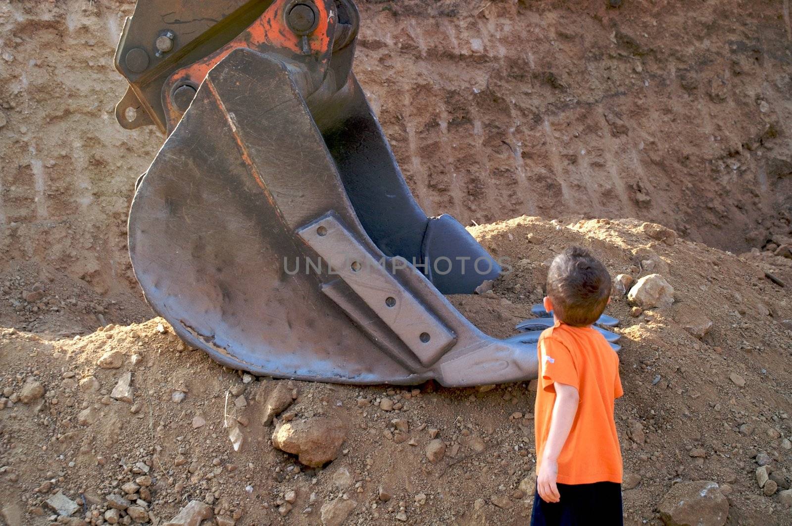 a boy looking at Bulldozer carefully by olgaolga