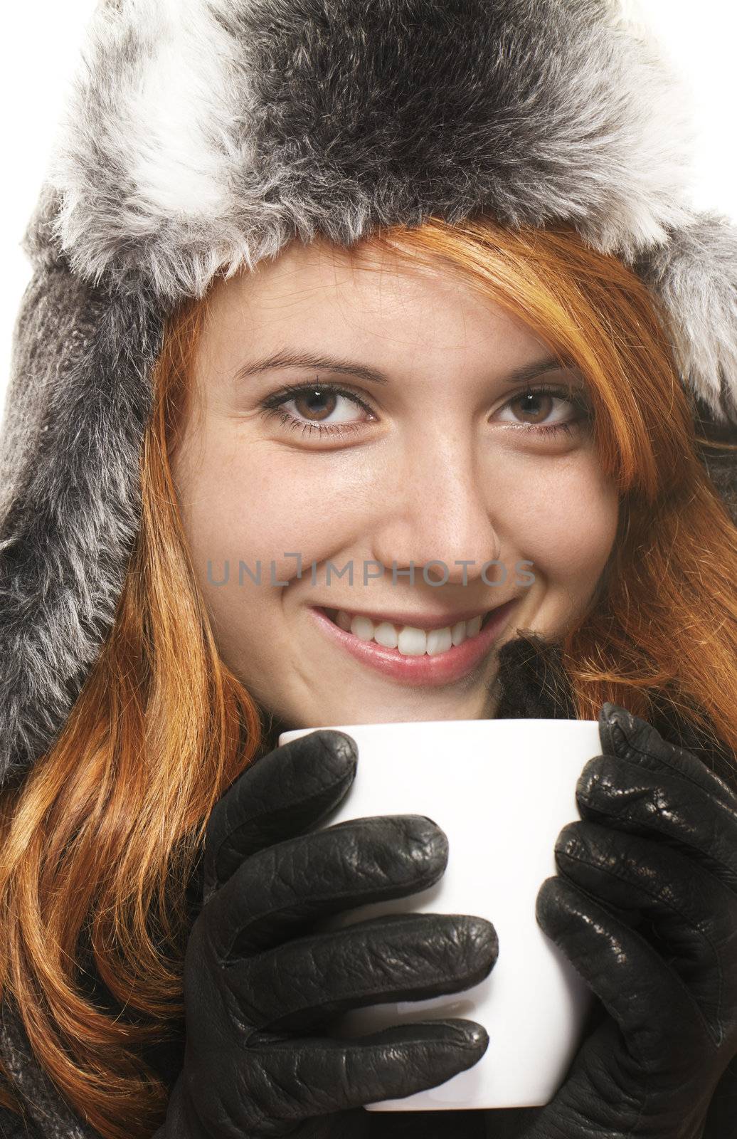 smiling young redhead woman in winter dress holding coffee cup  on white background