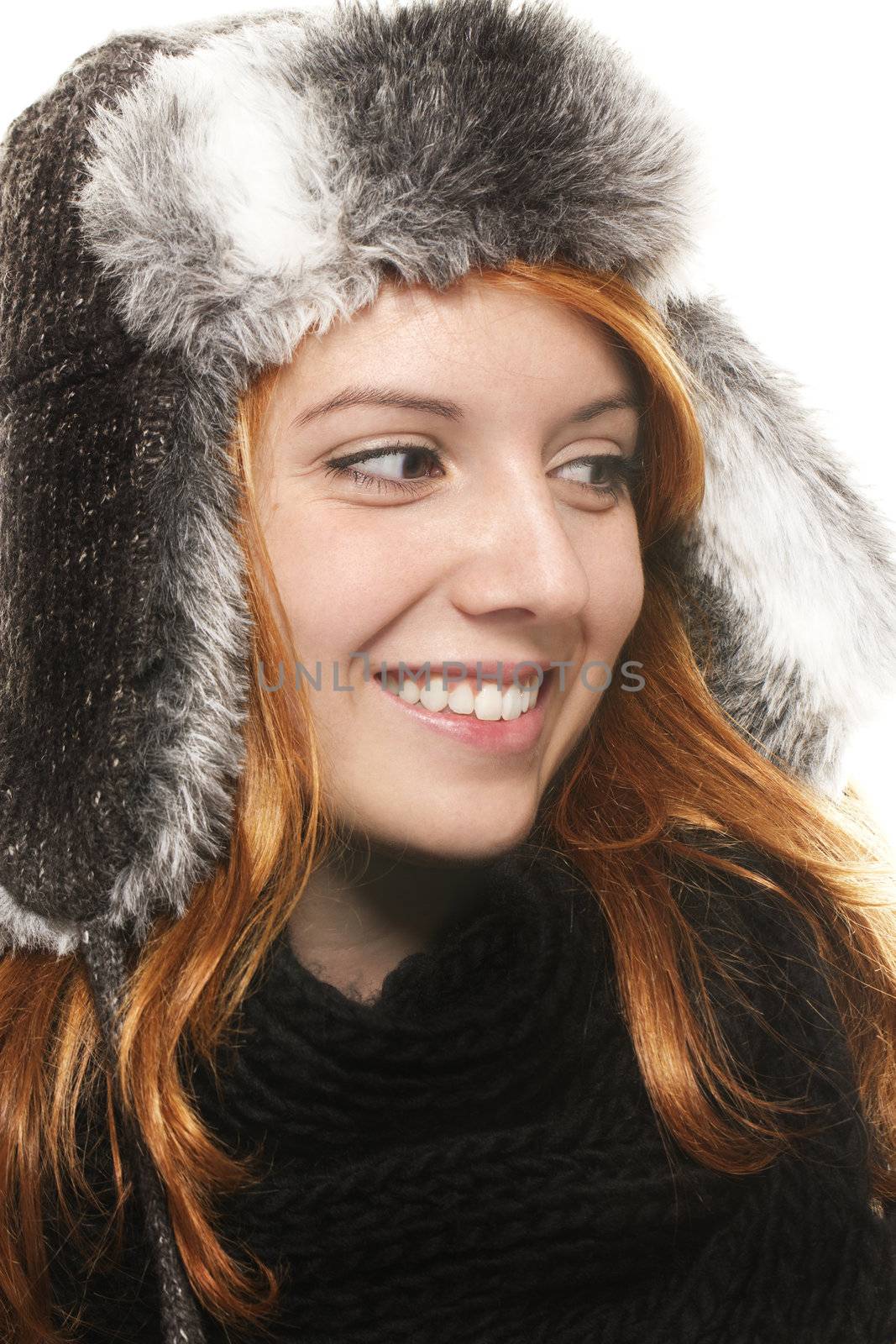smiling young redhead woman in winter dress looking on side on white background