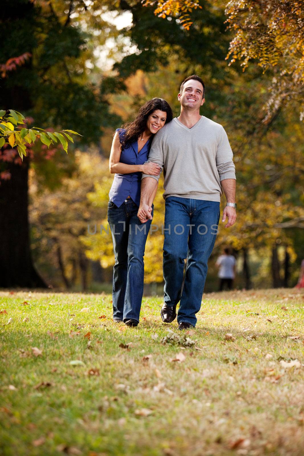 A happy couple walking in the park on grass