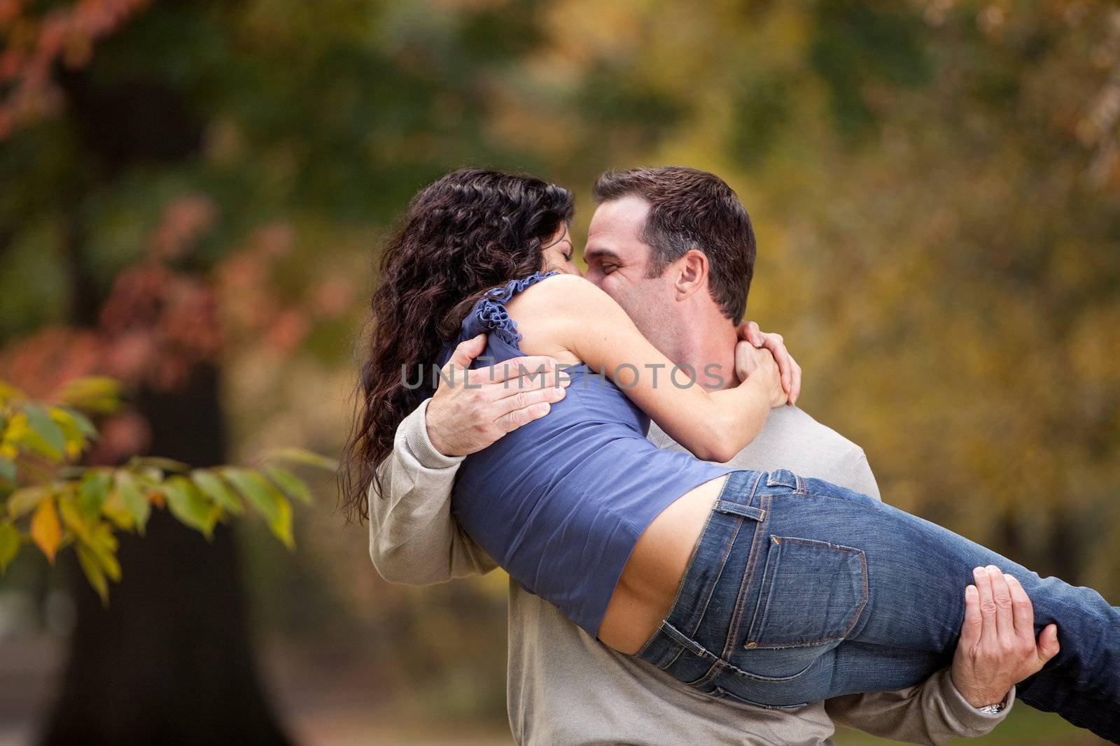 A playful couple - man holding woman in the park