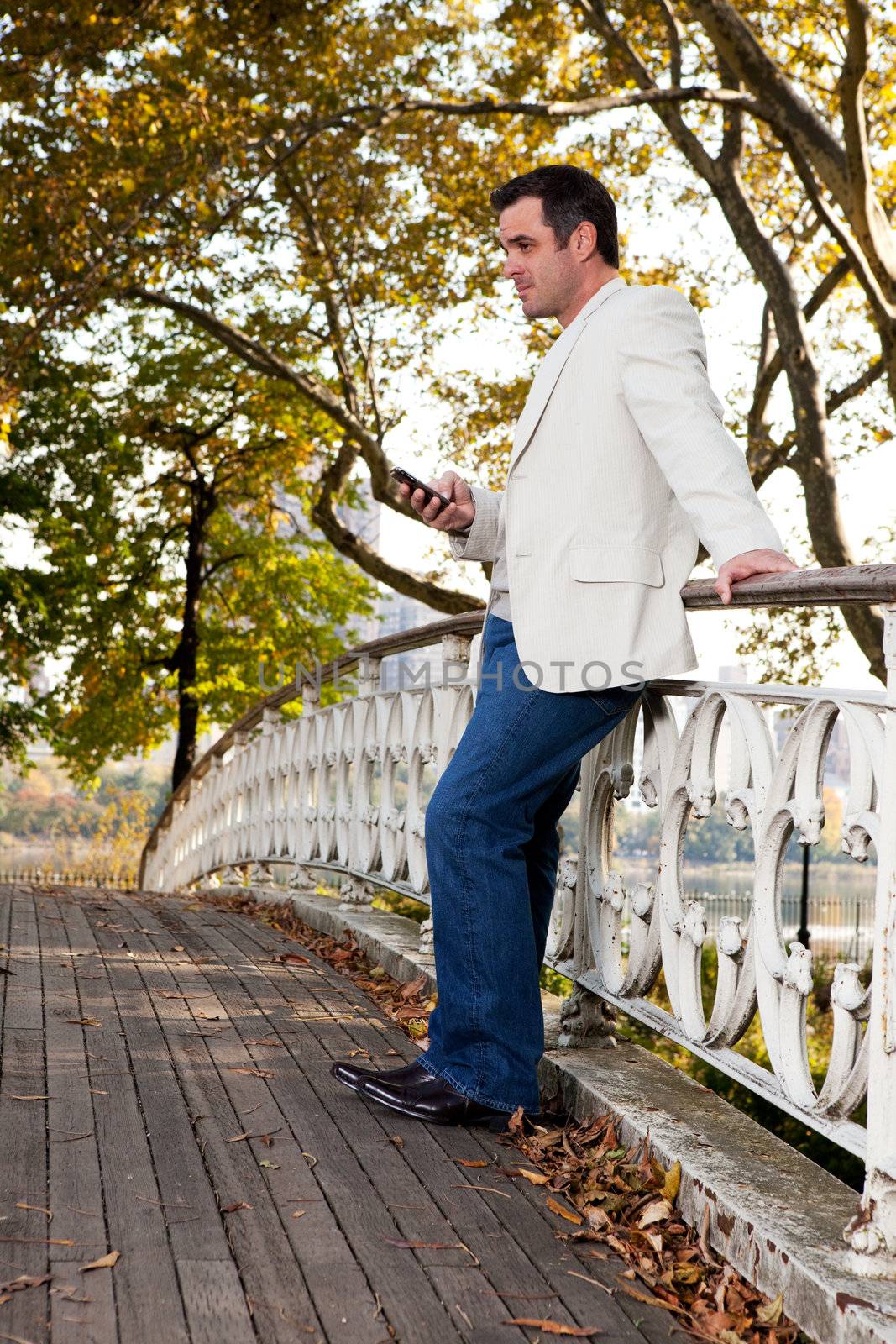 A man checking his cell phone in a park