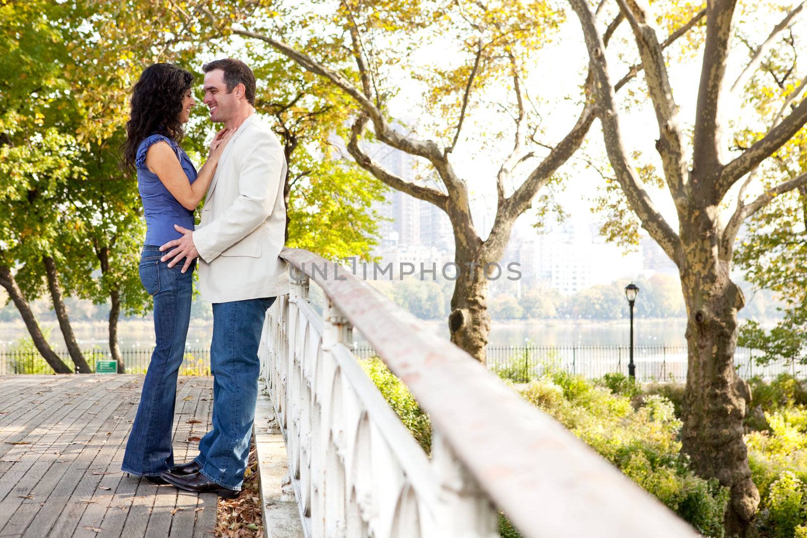 A couple smiling and looking at eachother in a park