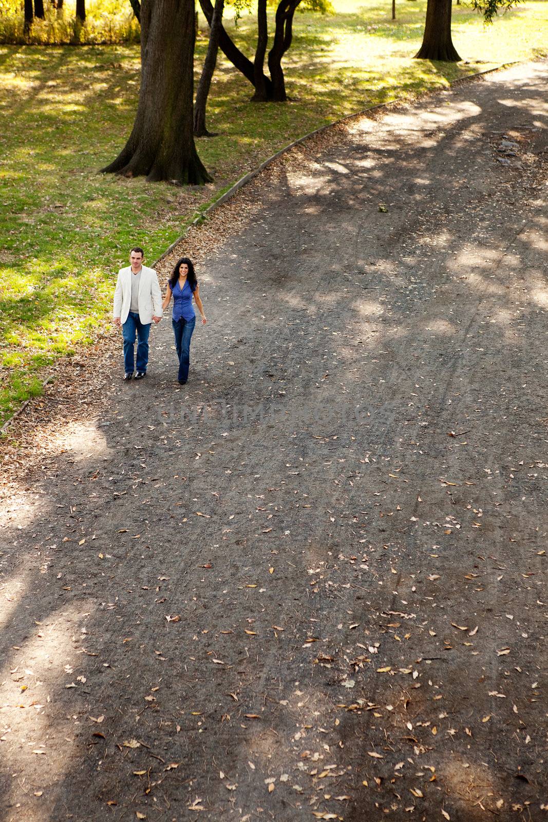 A happy couple walking in the park on a sunny day