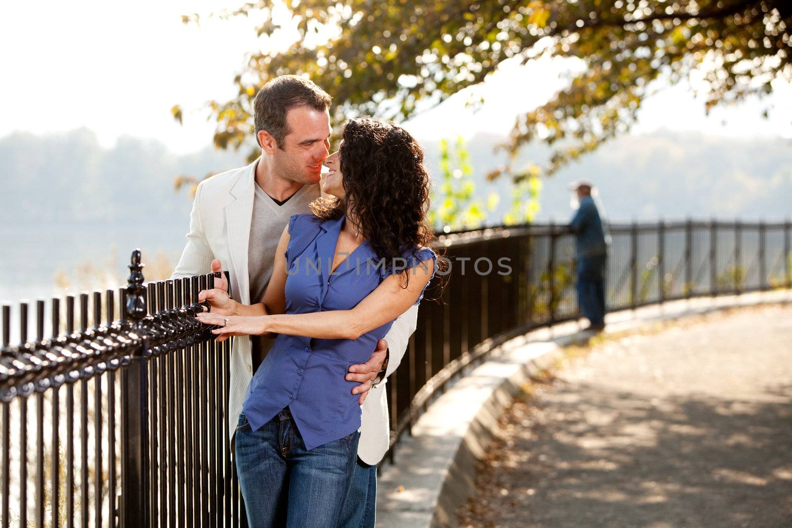 A happy couple kissing in the park on a beautiful day