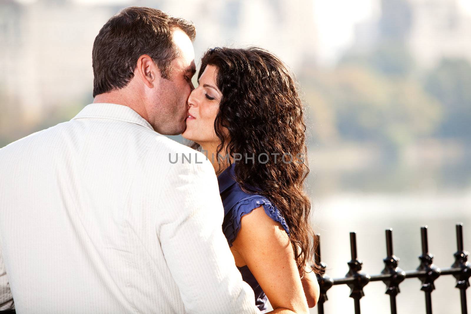 A man and woman kissing in a park