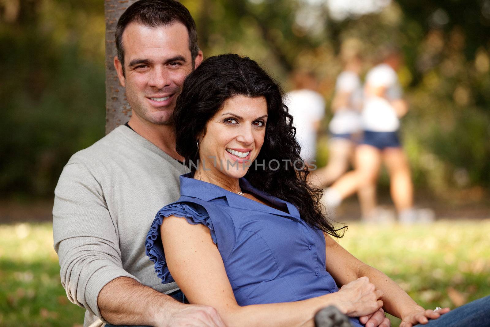 A happy married couple relaxing in the park - focus on the woman