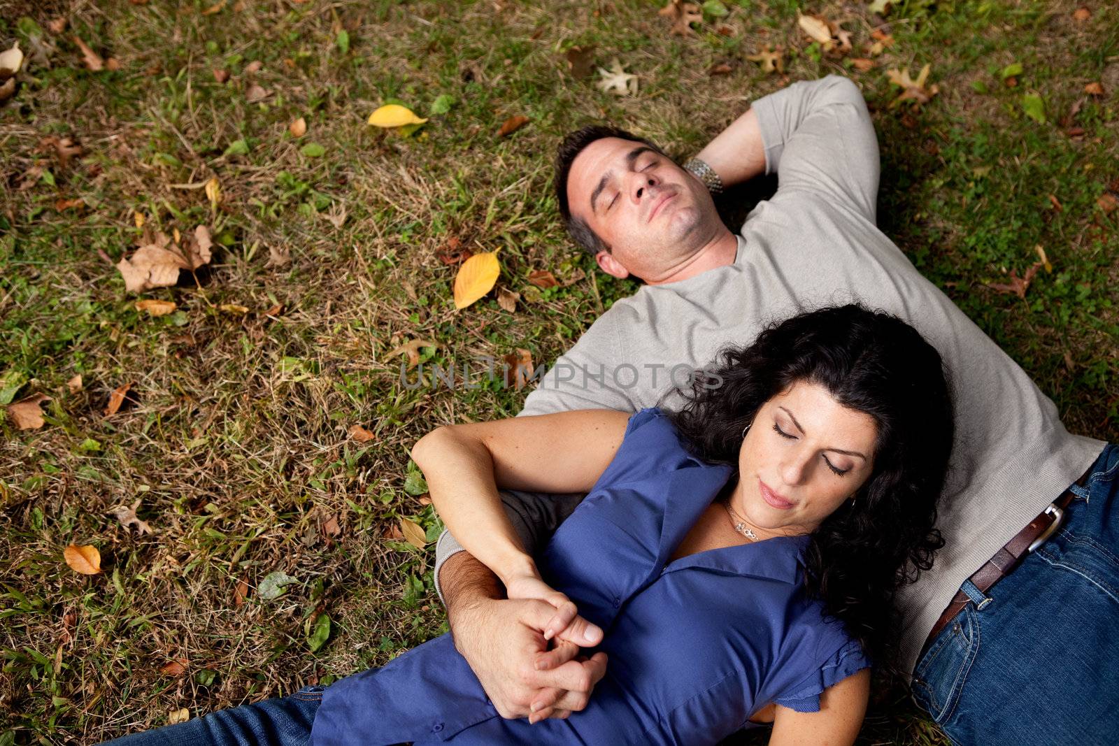 A couple laying on grass dreaming - sharp focus on female