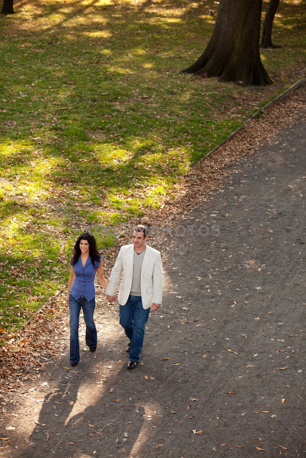 A man and woman walking in a park on a sunny day