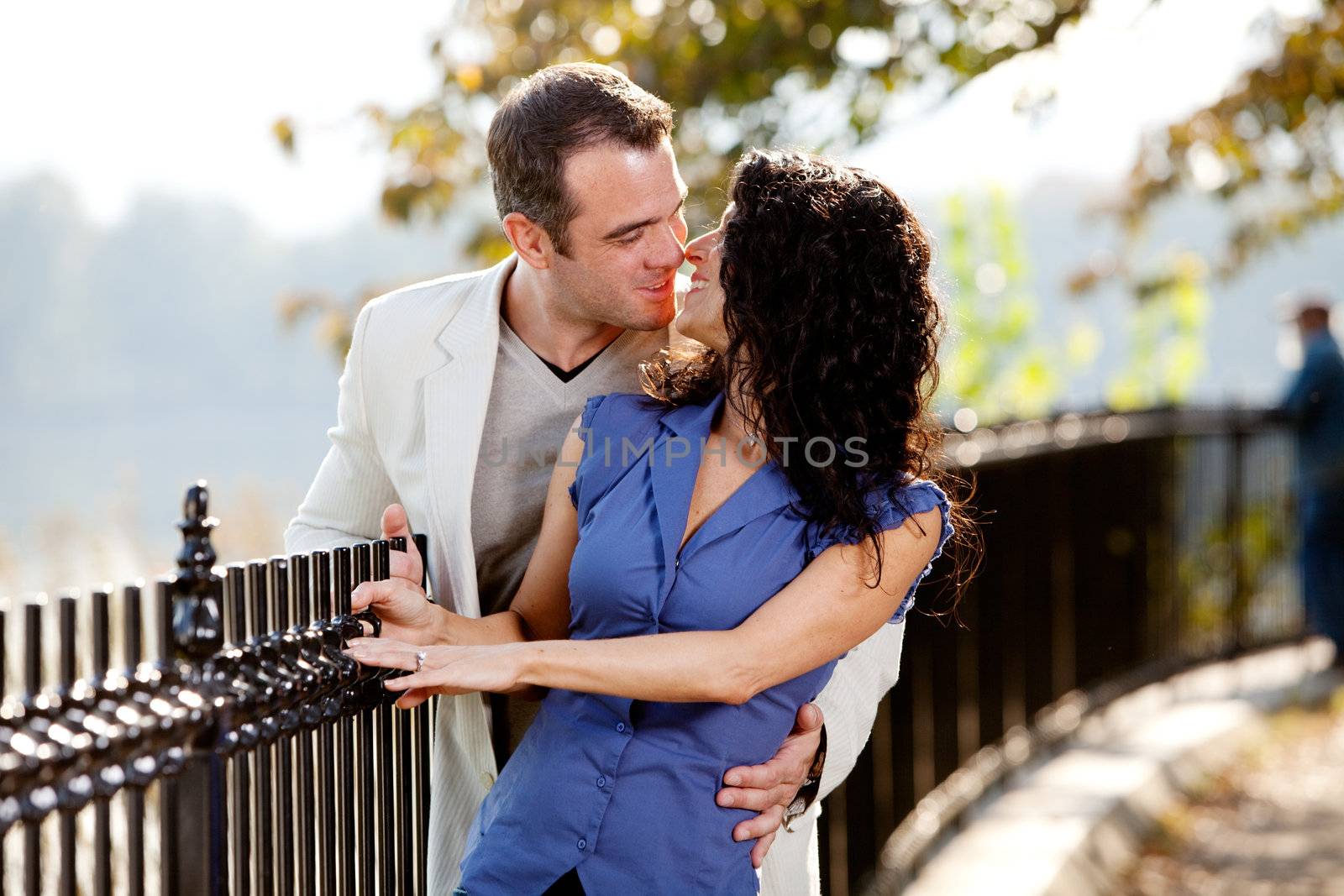 A happy couple kissing in the park on a beautiful day