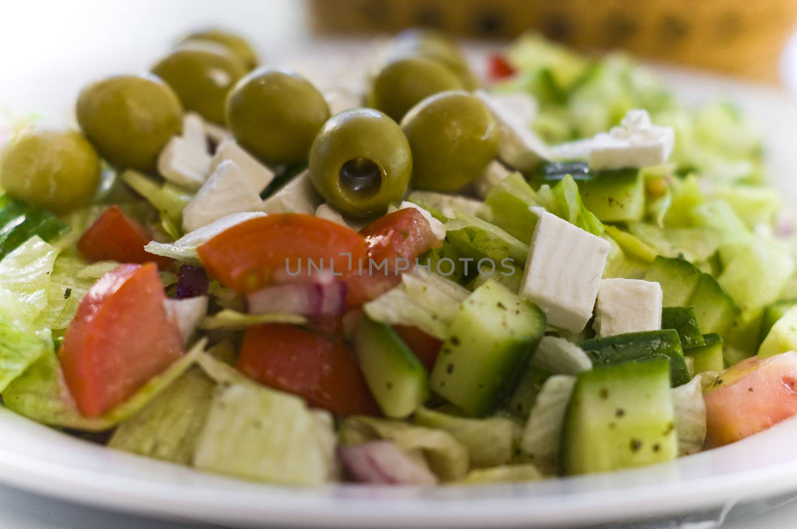 Traditional Greek salad closeup with cucumber, feta, lime and olives 