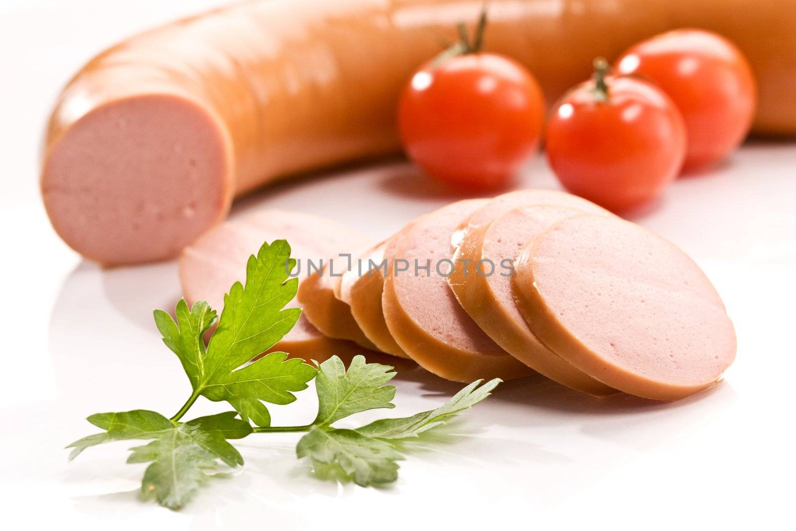 Cut boiled sausage with parsley and tomato