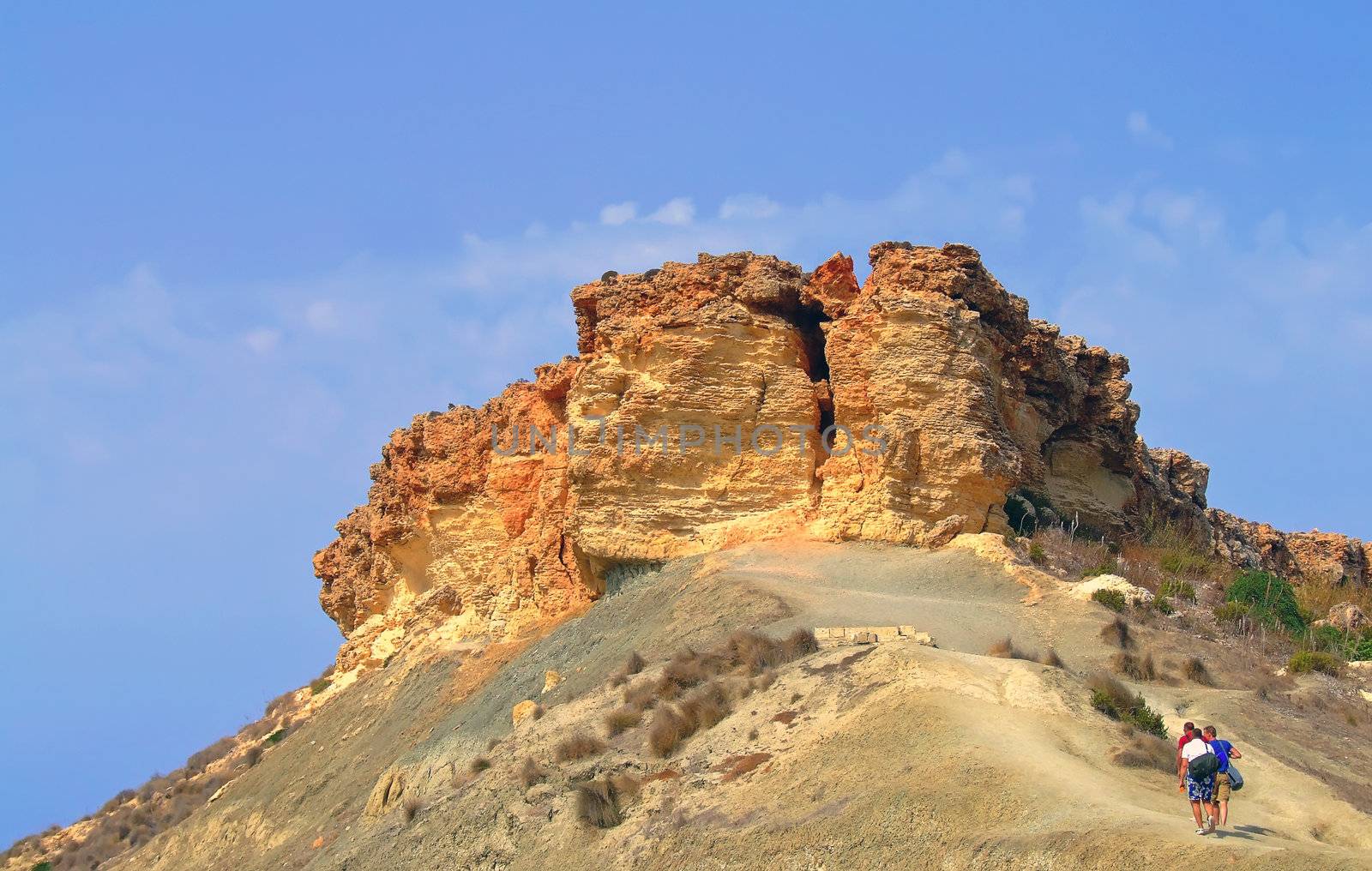 Adventure trio climbing up trek to the peak on top of clay slopes in Malta 