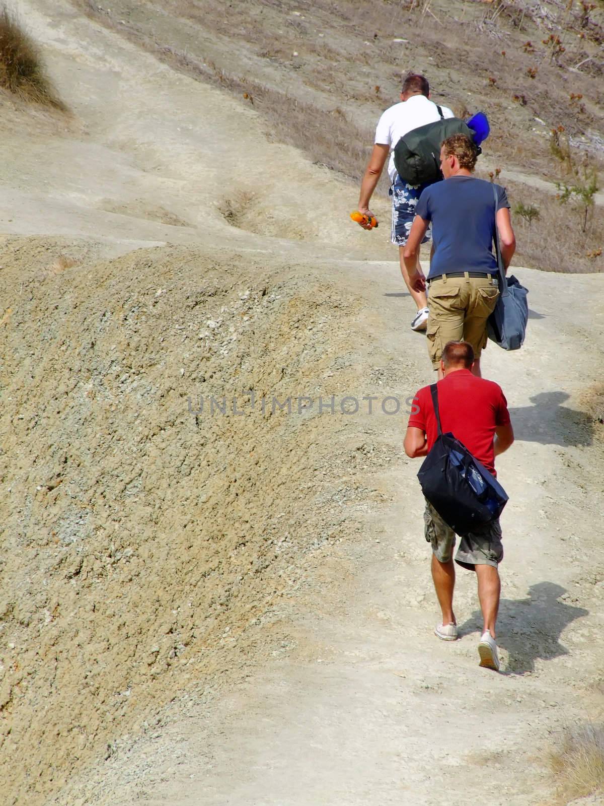 Adventure trio climbing up trek to the peak on top of clay slopes in Malta 