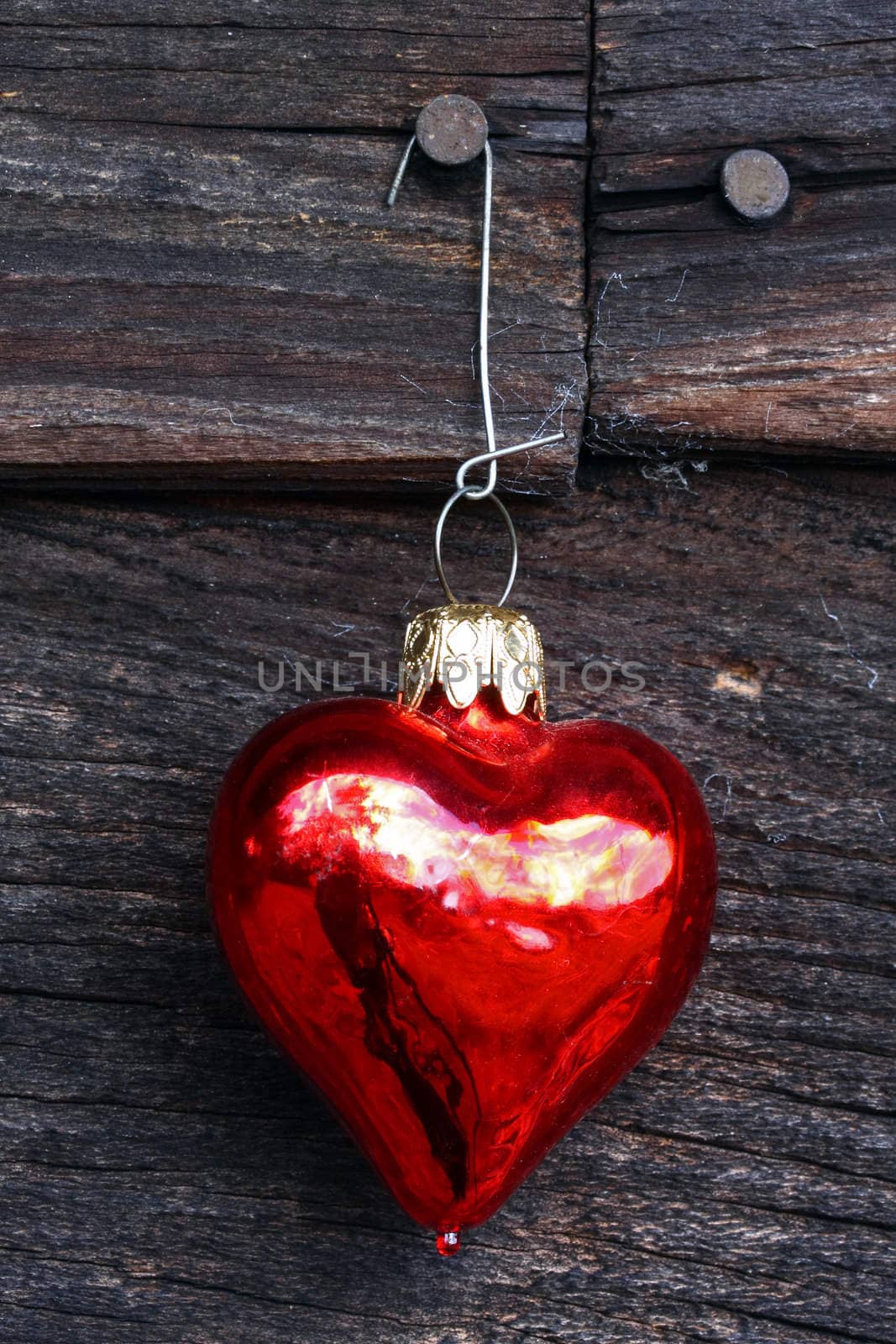 Heart ornament on wood, vertical.