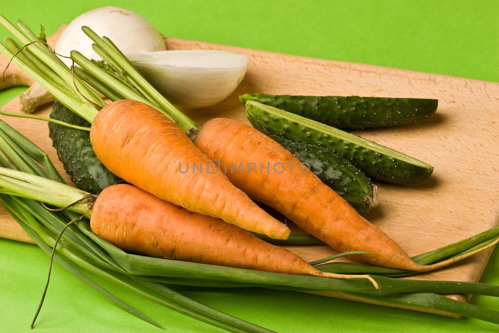 vegeterian food, fresh vegetables: onion, carrot, cucumber on the board