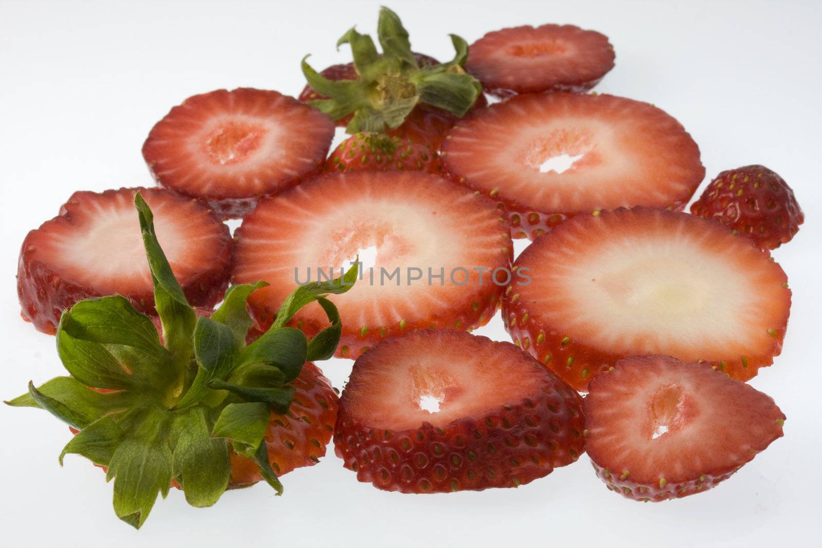 two fresh red strawberries with green leaves sliced