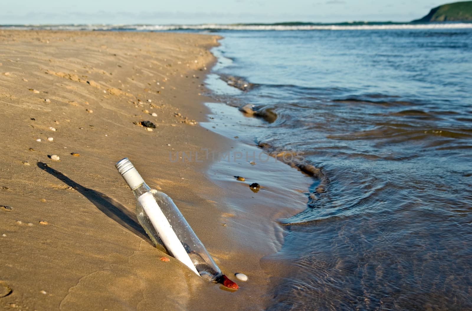 great image of a message in a bottle at the waters edge