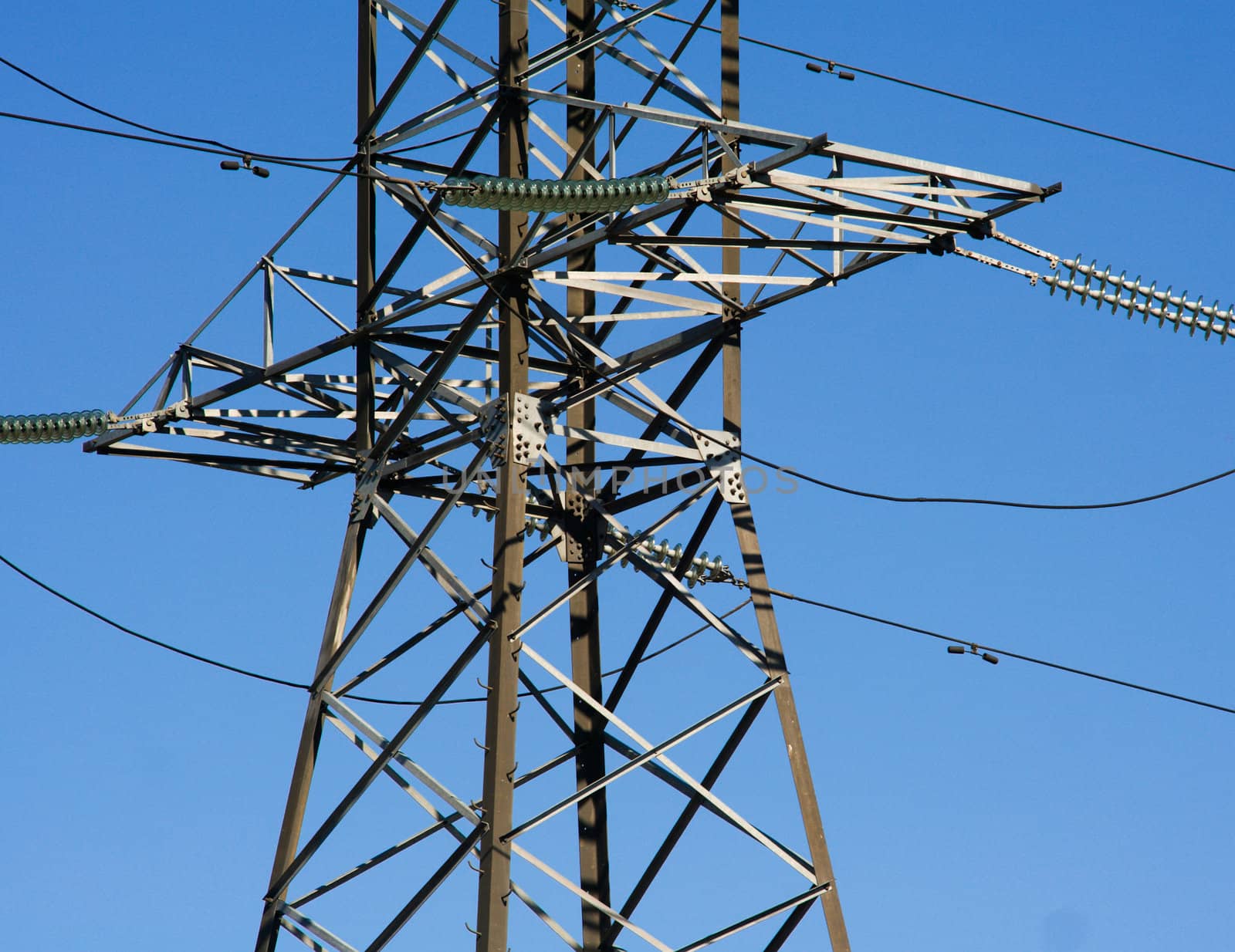 High voltage electricity closeup powerline on blue sky.