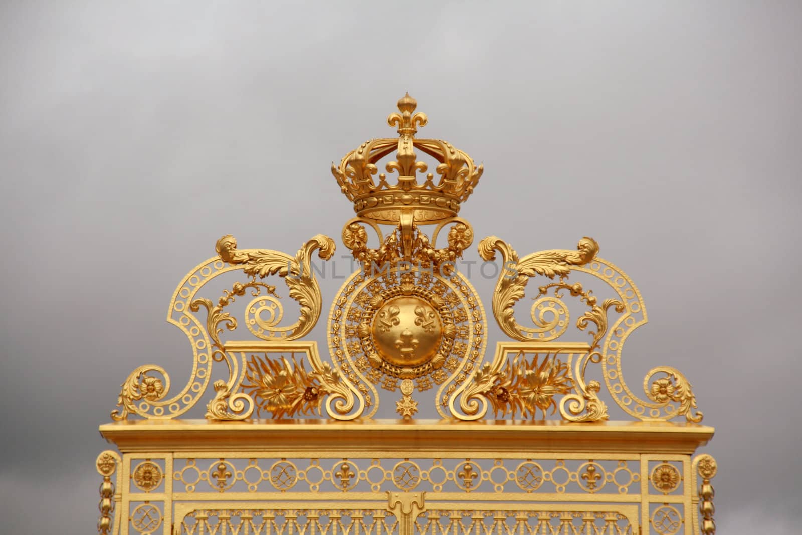 Park and Palace Chateau de Versailles. France. A fragment of the central gate with the royal crown and fleur lily