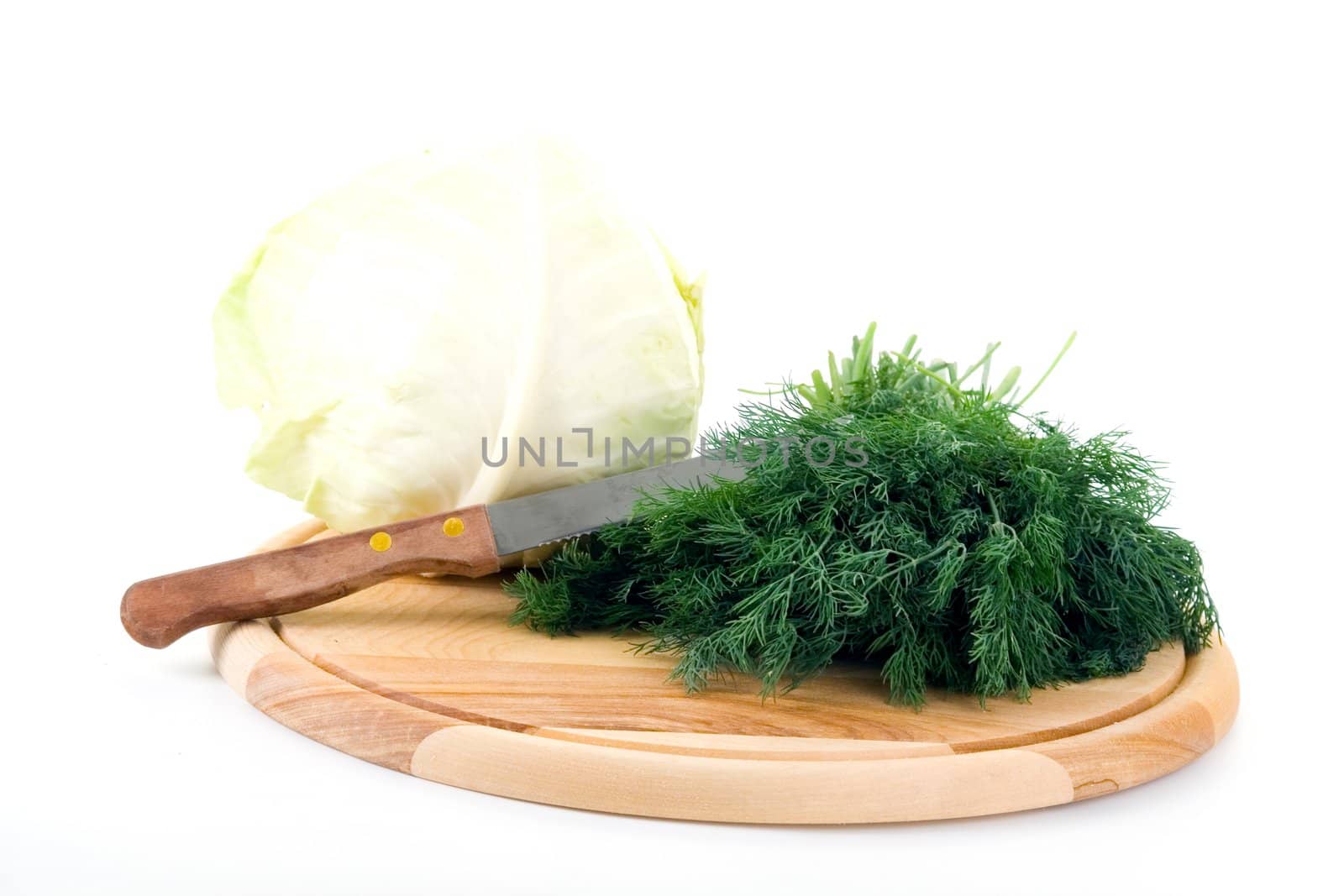Cabbage and fennel on a wooden cutting board on a white background