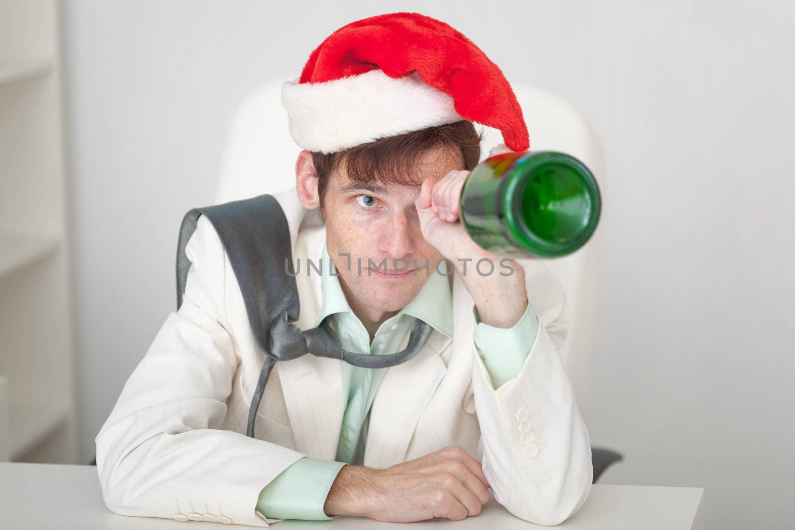 Amusing guy in Christmas cap with bottle in a hand by pzaxe