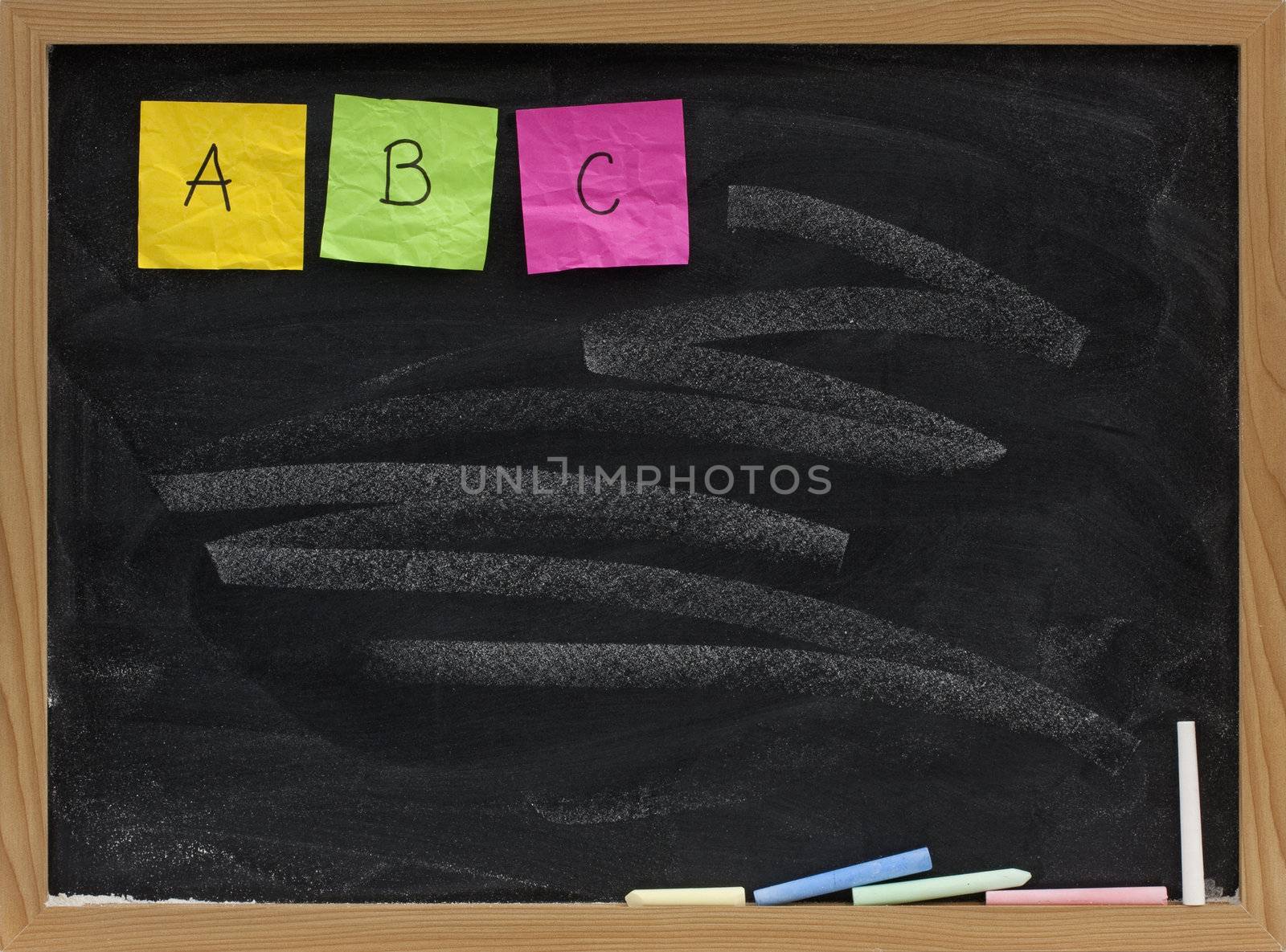 A, B, C - first three letters of alphabet displayed with sticky notes on blackboard with white chalk smudge pattern