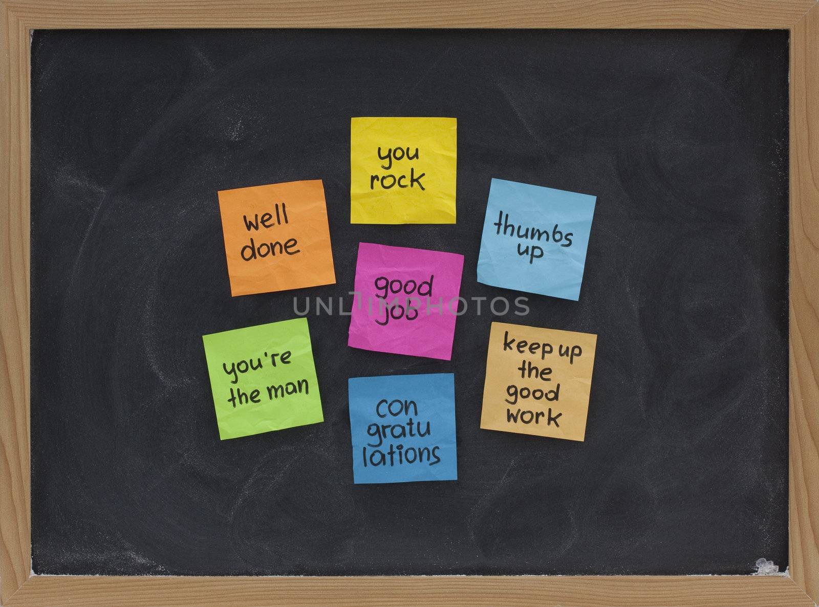 good job, well done, your rock, congratulations and other compliments - colorful sticky notes on blackboard with white chalk smudges