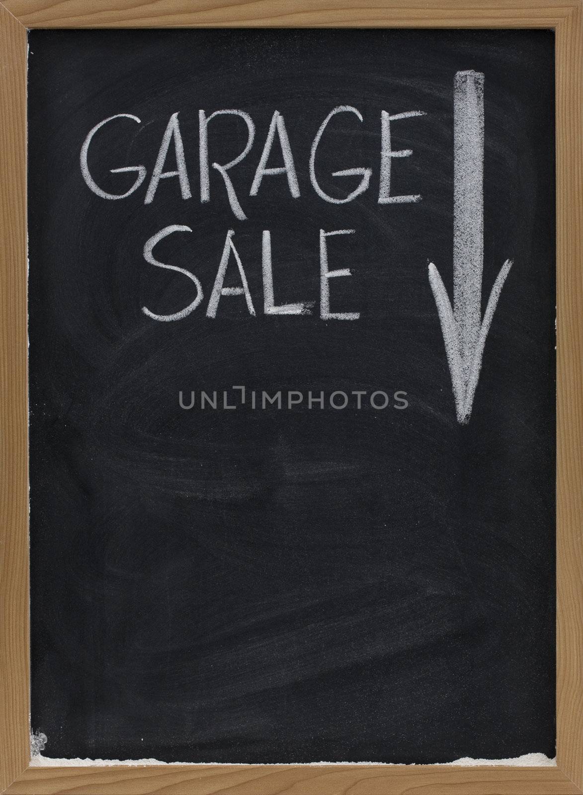 garage sale text handwritten with white chalk on vertical blackboard with arrow and copy space below