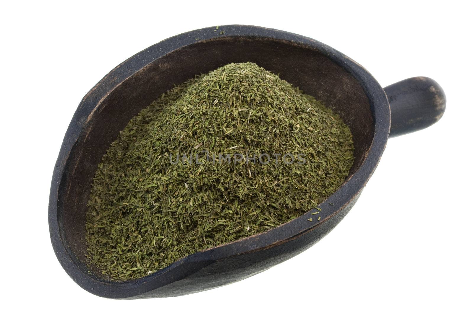 dried dill weed on a rustic wooden scoop isolated on white