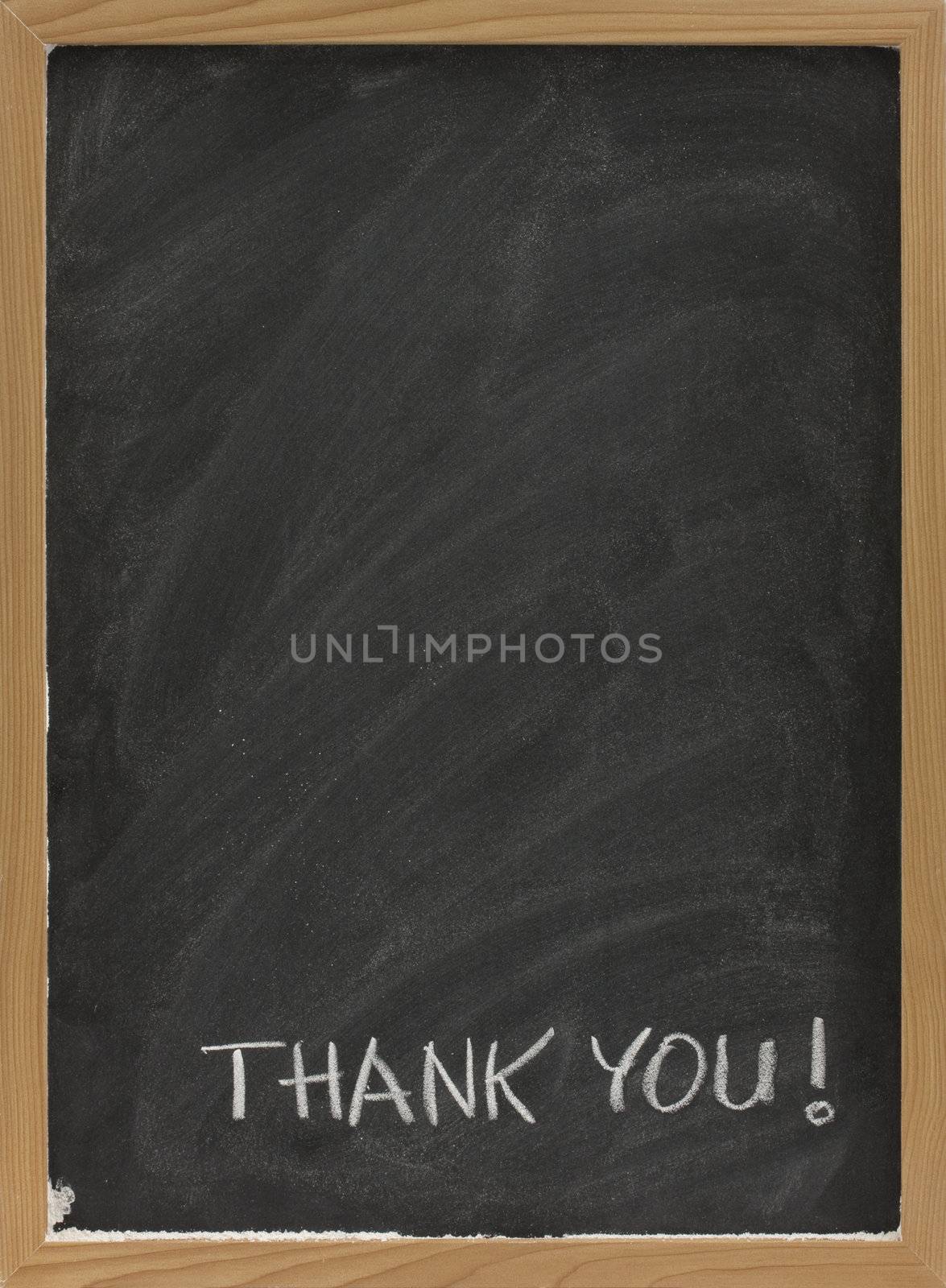 thank you handwritten with white chalk on blank blackboard with eraser smudges