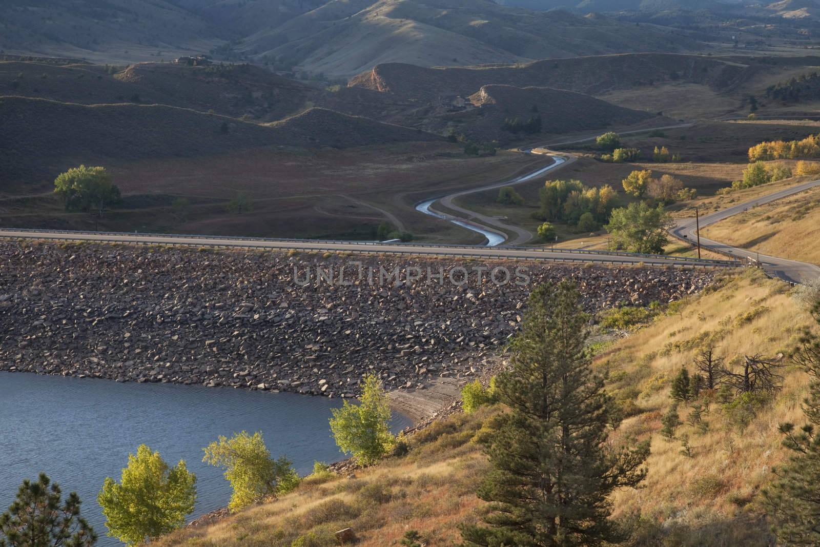 rock dam on Horsetooth Reservoir at foothills of Rocky Mountains near Fort Collins, Colorado, Charles Canal below the dam is running water, early fall